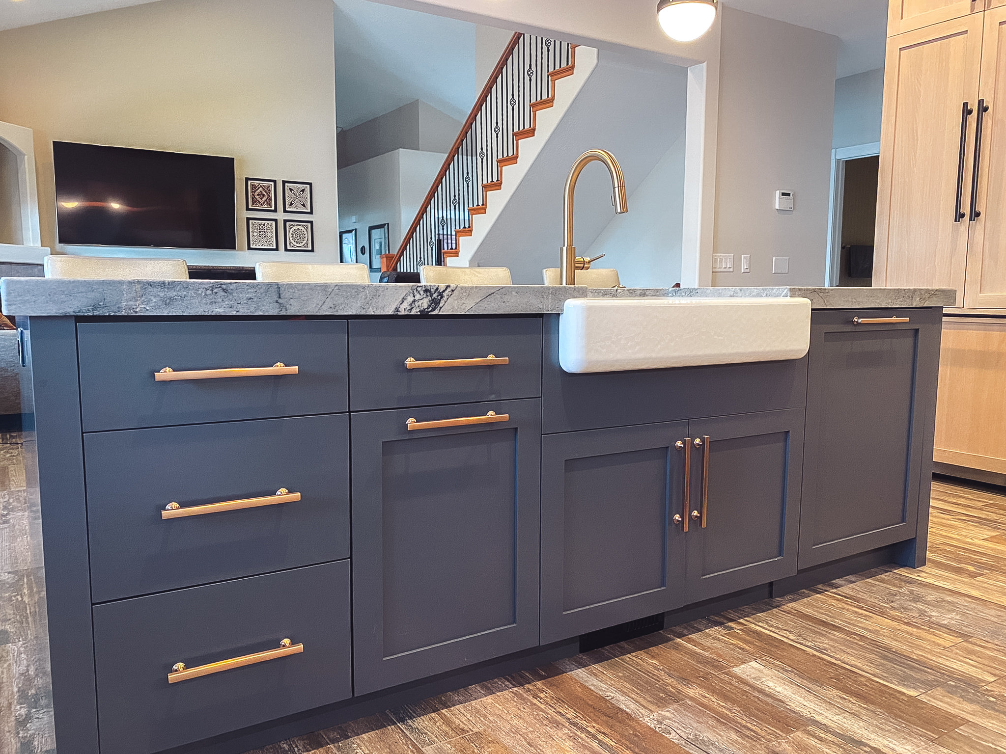 Close-up of kitchen island with navy blue cabinetry, new hardware, and granite countertops.