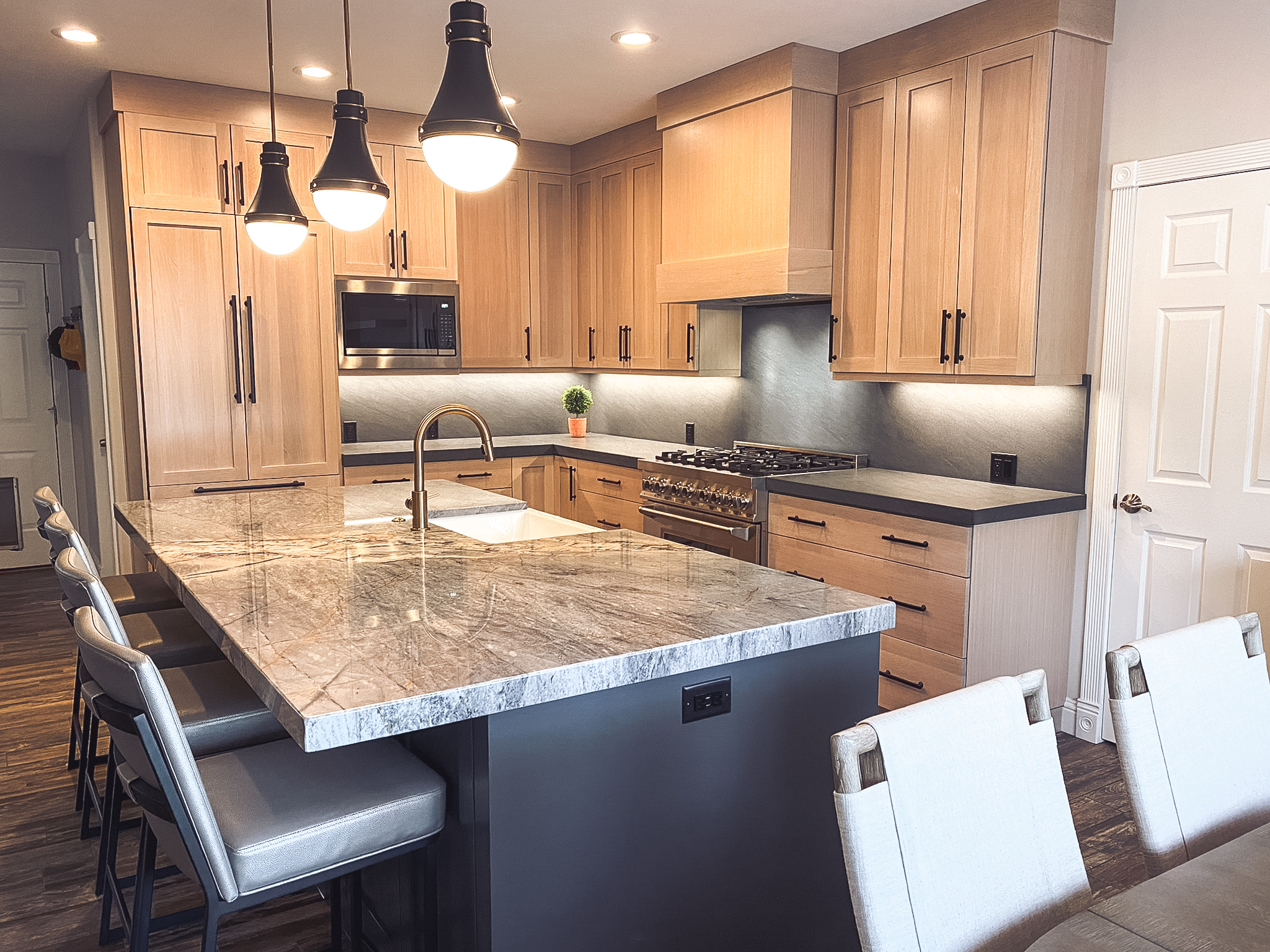Contemporary kitchen remodel with black island, modern cabinetry, floating shelves, and updated lighting.
